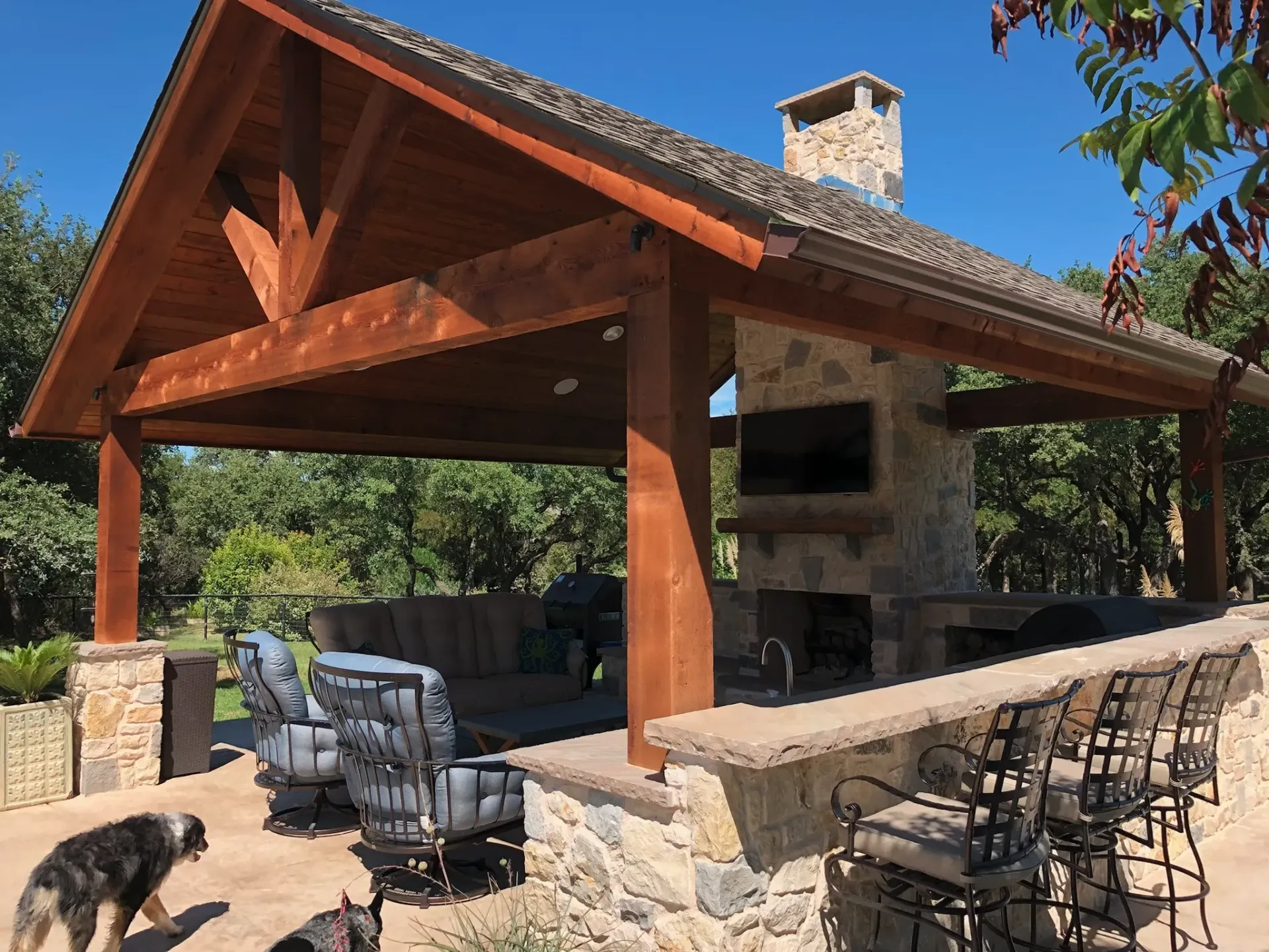 Outdoor living pavilion with stone fireplace and outdoor kitchen
